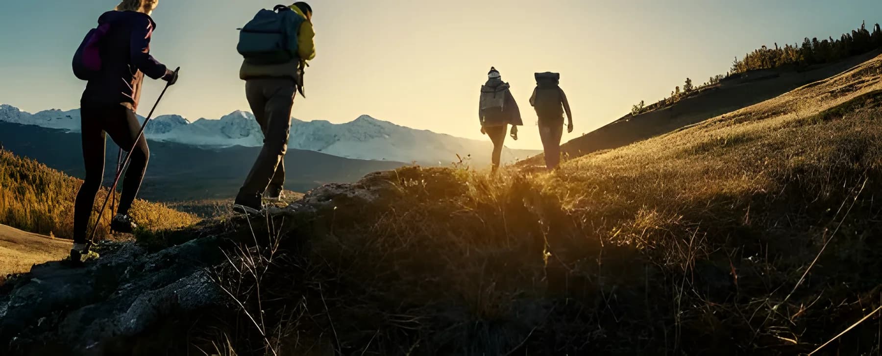 Two hikers walking a ridge at golden hour
